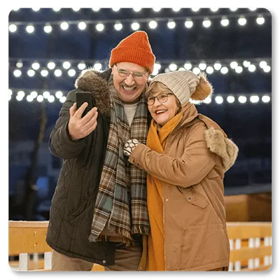 2 smiling people holding a phone