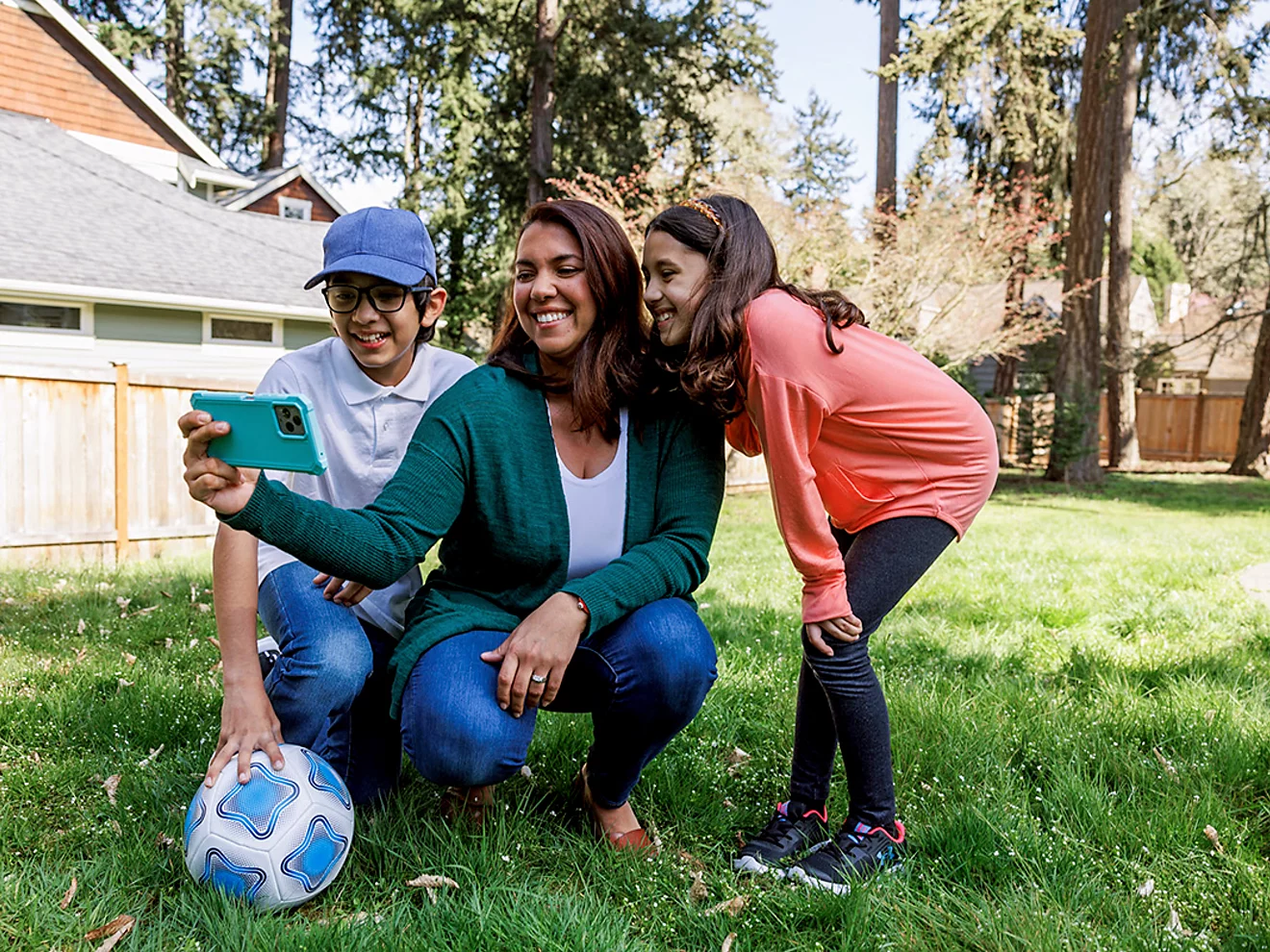 In the backyard, a mom and her kids pose for a selfie.