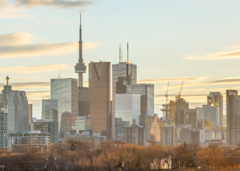 City skyline at sunset with CN Tower and city buildings in the background.